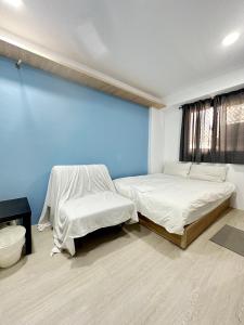 a bedroom with two beds and a blue wall at FunSong逢甲 in Taichung
