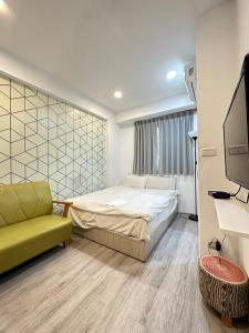 a bedroom with a bed and a couch and a tv at FunSong逢甲 in Taichung