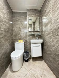 ein Badezimmer mit einem WC, einem Waschbecken und einem Spiegel in der Unterkunft FunSong逢甲 in Taichung