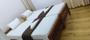 a bedroom with a bed with white and black sheets at Tess Holistay Fort Kochi in Fort Kochi