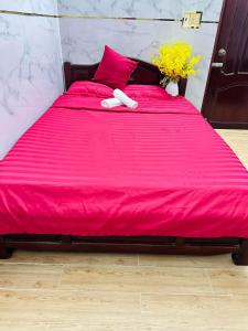 1 cama roja grande con sábanas rojas y almohadas rosas en Nhà nghỉ Trung Hiếu 1, en Bình Thủy