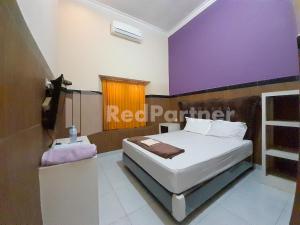 Postel nebo postele na pokoji v ubytování LH101 Guest House Syariah near Makam Sunan Bonang RedPartner