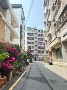 an empty street in a city with plants and buildings at FunSong逢甲 in Taichung
