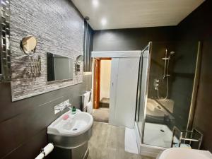 a bathroom with a sink and a toilet and a shower at Leeds City House in Leeds