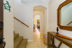 a hallway with a mirror and stairs in a house at Fairways at Mauna Lani #402 in Waikoloa