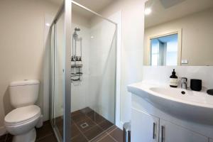 a white bathroom with a toilet and a sink at Eastside apartment in Charlestown +9 photos