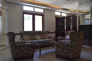 a living room with two chairs and a couch at Hotel Bumi Kitri in Bandung