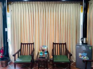 2 Stühle und ein Tisch vor einem Fenster in der Unterkunft Phước Lạc Duyên Garden House by ACC in Ấp Thanh Sơn (1)