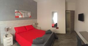 1 dormitorio con cama roja y sofá en Casa Vacanze Manu, en Galatina
