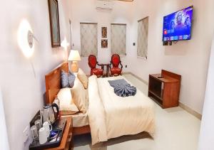 a bedroom with a bed and a tv in it at Cordial Hotels And Resorts Private Limited in Sītāpur