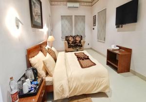 a bedroom with a large bed and a television at Cordial Hotels And Resorts Private Limited in Sītāpur