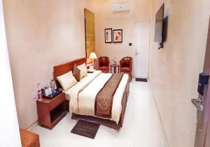 a hotel room with a bed and a table and chairs at Cordial Hotels And Resorts Private Limited in Sītāpur