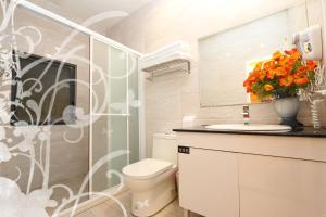 La salle de bains est pourvue de toilettes et d'un vase de fleurs. dans l'établissement Yun Cui Leisure B&B, à Lugu