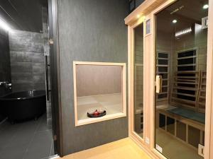 y baño con ducha y bañera. en FUMAI sauna &INN-遠赤外線サウナ-松江の歴史と文化と共に過ごすsmart hotel, en Matsue