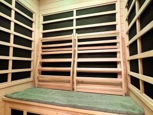 un armadio con ripiani in legno e una panca verde di FUMAI sauna &INN-遠赤外線サウナ-松江の歴史と文化と共に過ごすsmart hotel a Matsue