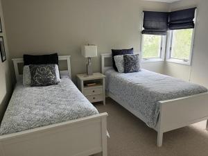 ein weißes Schlafzimmer mit 2 Betten und einem Fenster in der Unterkunft Modern Well Kept Single Family House in Waretown