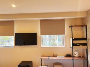 Habitación con 2 ventanas y TV de pantalla plana. en N+HOTEL東京日本橋, en Tokio