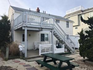 ein Haus mit einer Terrasse und einem Picknicktisch in der Unterkunft Second Floor Condo Just Steps To The Beach! in Beach Haven