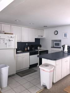 une cuisine avec des placards blancs et un comptoir noir dans l'établissement One House From The Beach!, à Beach Haven