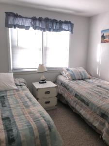 - une chambre avec deux lits à côté d'une fenêtre dans l'établissement One House From The Beach!, à Beach Haven