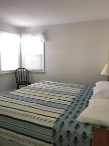- une chambre avec un grand lit et une couverture rayée dans l'établissement One House From The Beach!, à Beach Haven