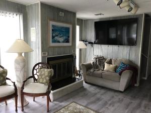 a living room with a couch and a fireplace at Ocean Views In Loveladies! in Loveladies