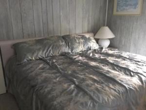 a bed with a silver comforter in a bedroom at Ocean Views In Loveladies! in Loveladies +4 photos