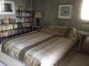 a bedroom with a bed and bookshelves filled with books at Ocean Views In Loveladies! in Loveladies