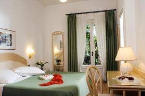 a hotel room with a bed and a table with a red towel on it at Hotel Villa Angelica in Ischia