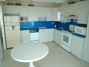 a kitchen with white appliances and a white table in it at Nice Home In Brant Beach With 4 Bedrooms And Internet in Brant Beach