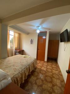 a hotel room with a bed and a television at Hostal Sirena in Ica