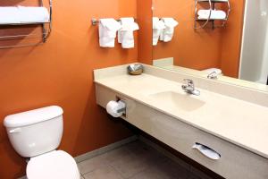 La salle de bains est pourvue d'un lavabo, de toilettes et d'un miroir. dans l'établissement Scottish Inns Killeen near Fort Cavazos, à Killeen