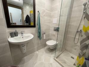 Un baño con inodoro, lavabo y ducha. en Panoramic Sea View Apartment - Perfect for Couples, en Varna