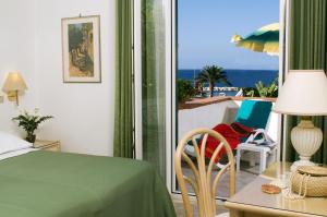 a bedroom with a bed and a view of the ocean at Hotel Villa Angelica in Ischia
