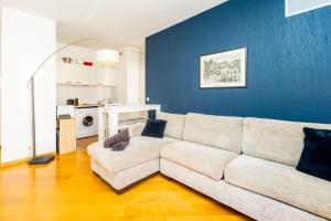 a living room with a couch and a blue wall at Palais Magnan Lux 4 Pers WiFi AC in Nice