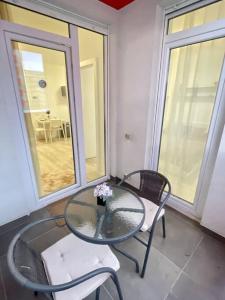 einen Glastisch und zwei Stühle auf dem Balkon in der Unterkunft Sunlit Shelter * Ideal Location! Free Parking in Oradea