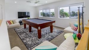 a living room with a pool table in it at Luxury & Style On The Canal in Banksia Beach