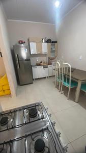 une cuisine avec une cuisinière en acier inoxydable et une table dans l'établissement Casa Azul do Capão, à Palmeiras