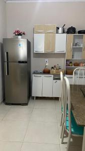 una cucina con frigorifero e tavolo con sedie di Casa Azul do Capão a Palmeiras