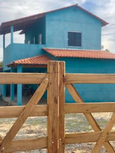 a wooden fence in front of a blue house at Casa Azul do Capão in Palmeiras