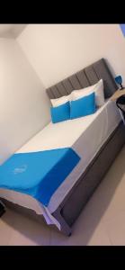 a bedroom with a bed with blue pillows at Hotel House in Medellín