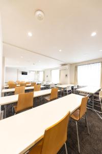 una sala conferenze vuota con tavoli e sedie di Reco Hotel Mikuni a Toyonaka