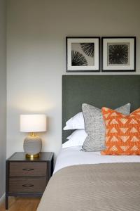 a bedroom with a bed and a lamp on a night stand at Cosy tastefully decorated flat in Rainham in Rainham