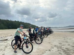 un grupo de personas montando bicicletas en la playa en Ocean Cottage 1, Radiant Teluk Sari en Kampung Mawar
