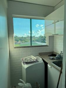 eine Küche mit einer Waschmaschine und einem Fenster in der Unterkunft LINDO AP no Condomínio Topázio in Rio Branco