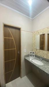 a bathroom with a sink and a door with a mirror at Casa Azul do Capão in Palmeiras