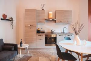 a living room with a table and a kitchen at DUPLEX with Terrace - 6 min walk to Bernina Express in Tirano