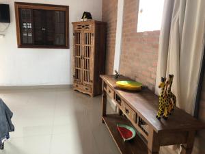 Pousada Chácara da Índia في إيتاتيايا: غرفة مع طاولة خشبية في غرفة
