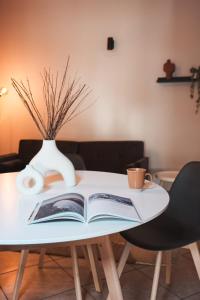 a book on a table with a cup and a vase at DUPLEX con VISTA e TERRAZZA [6 minuti dal Bernina Express] in Tirano