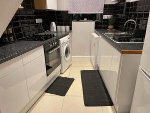 eine Küche mit einer Waschmaschine und einem Waschbecken in der Unterkunft Holloway one bedroom apartment in London